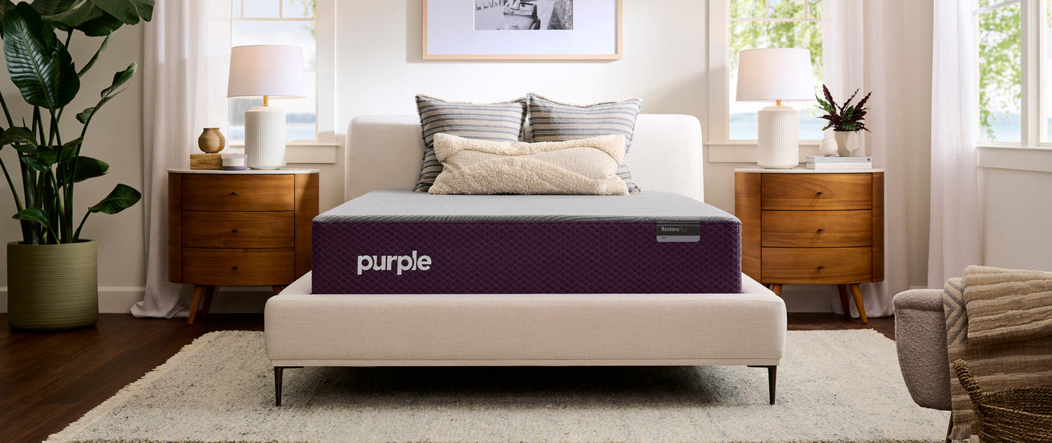 Purple mattress on a bed in a bedroom setting with decor elements.