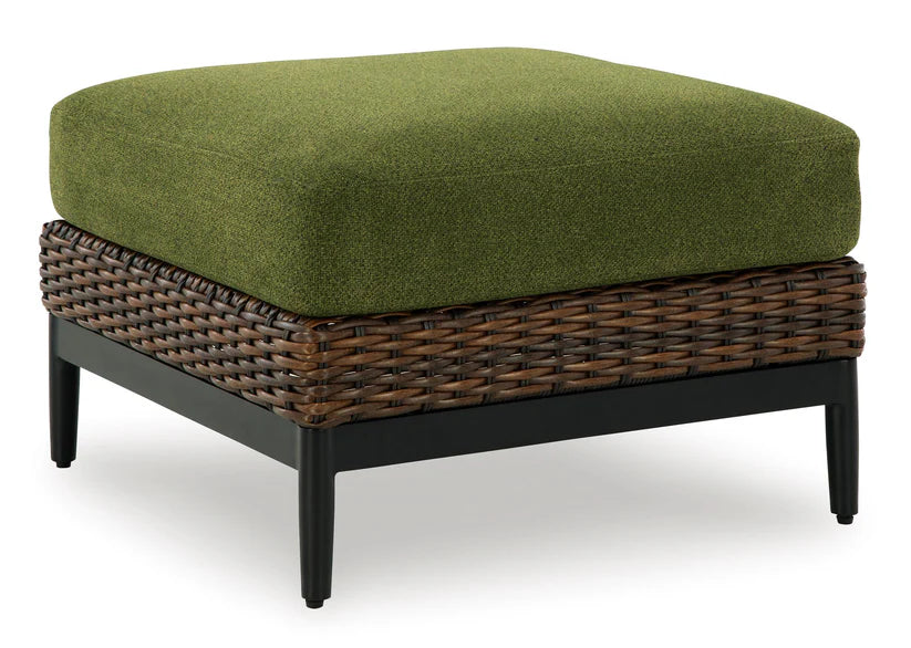 Green cushioned ottoman with wicker frame on a white background
