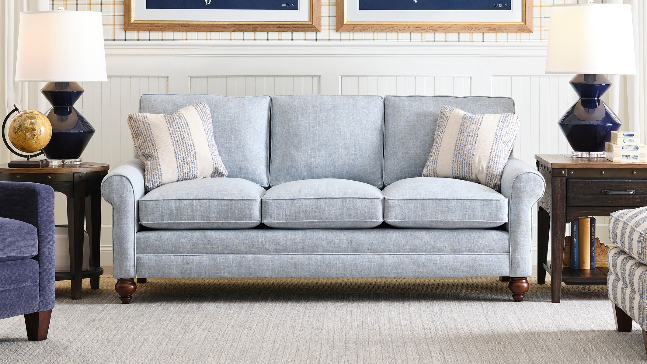 Living room with a light blue sofa, armchair, and side tables.