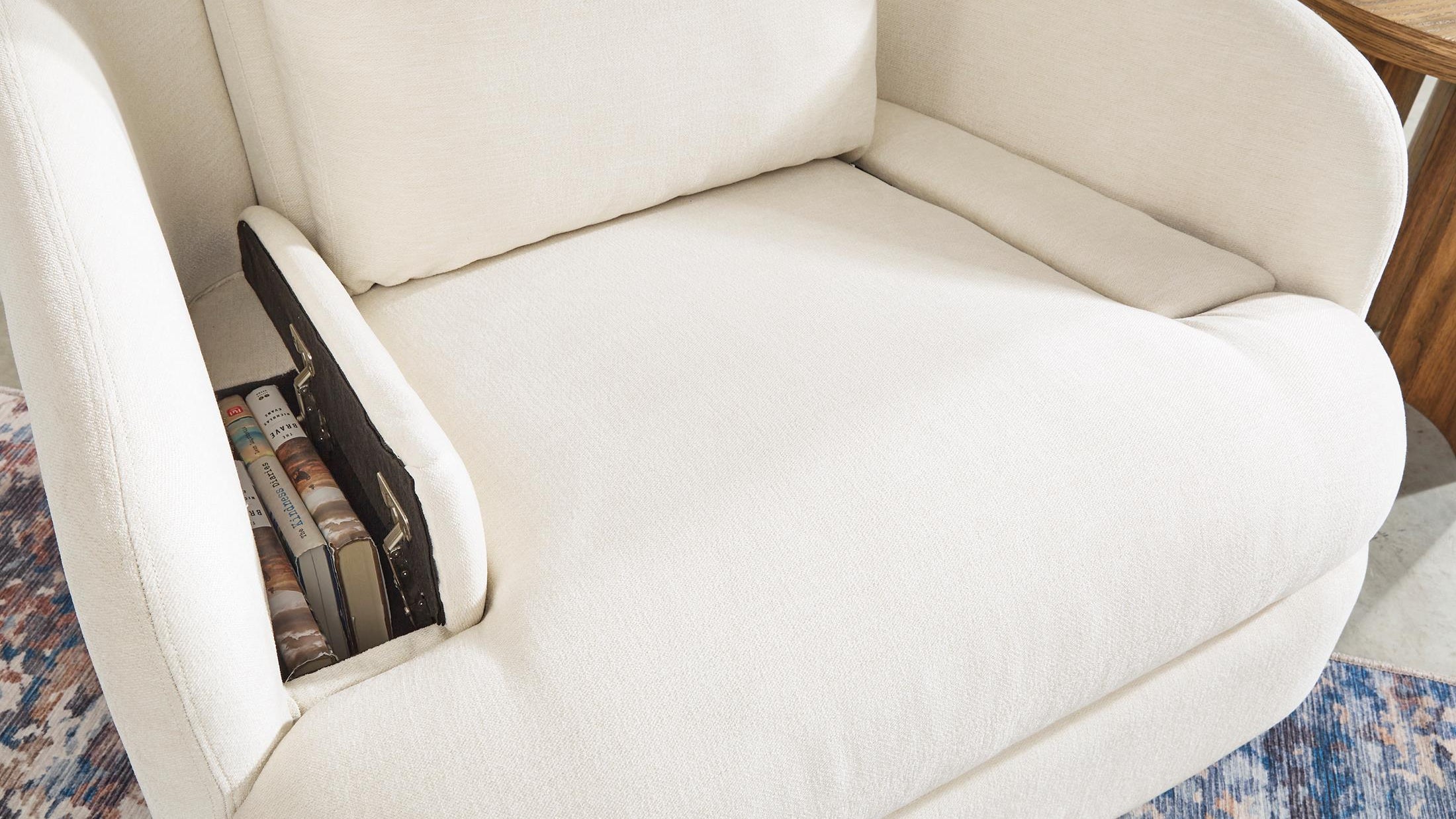 White recliner chair with a hidden storage pocket with books 