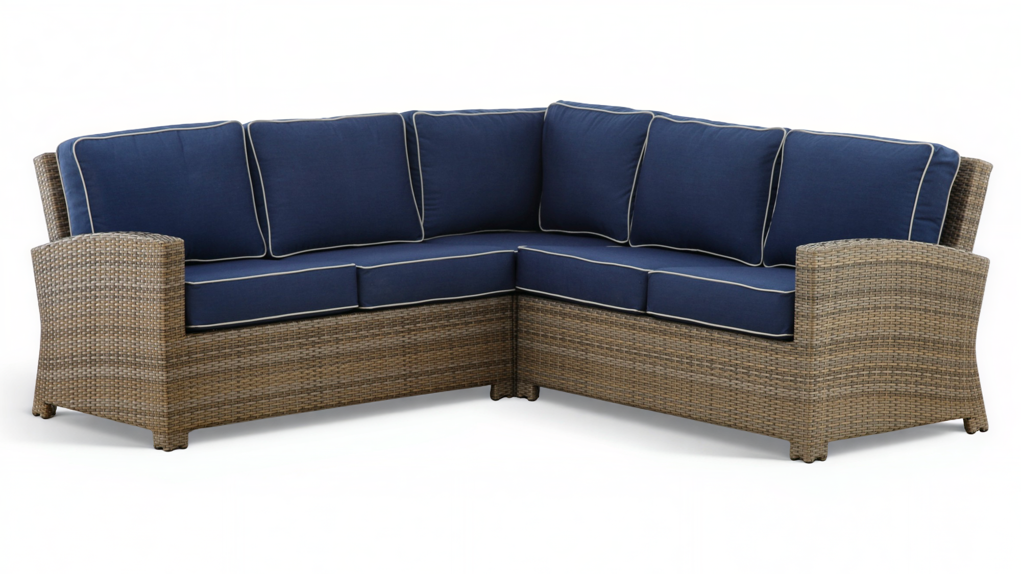 Sectional outdoor sofa with wicker frame and navy cushions on a white background