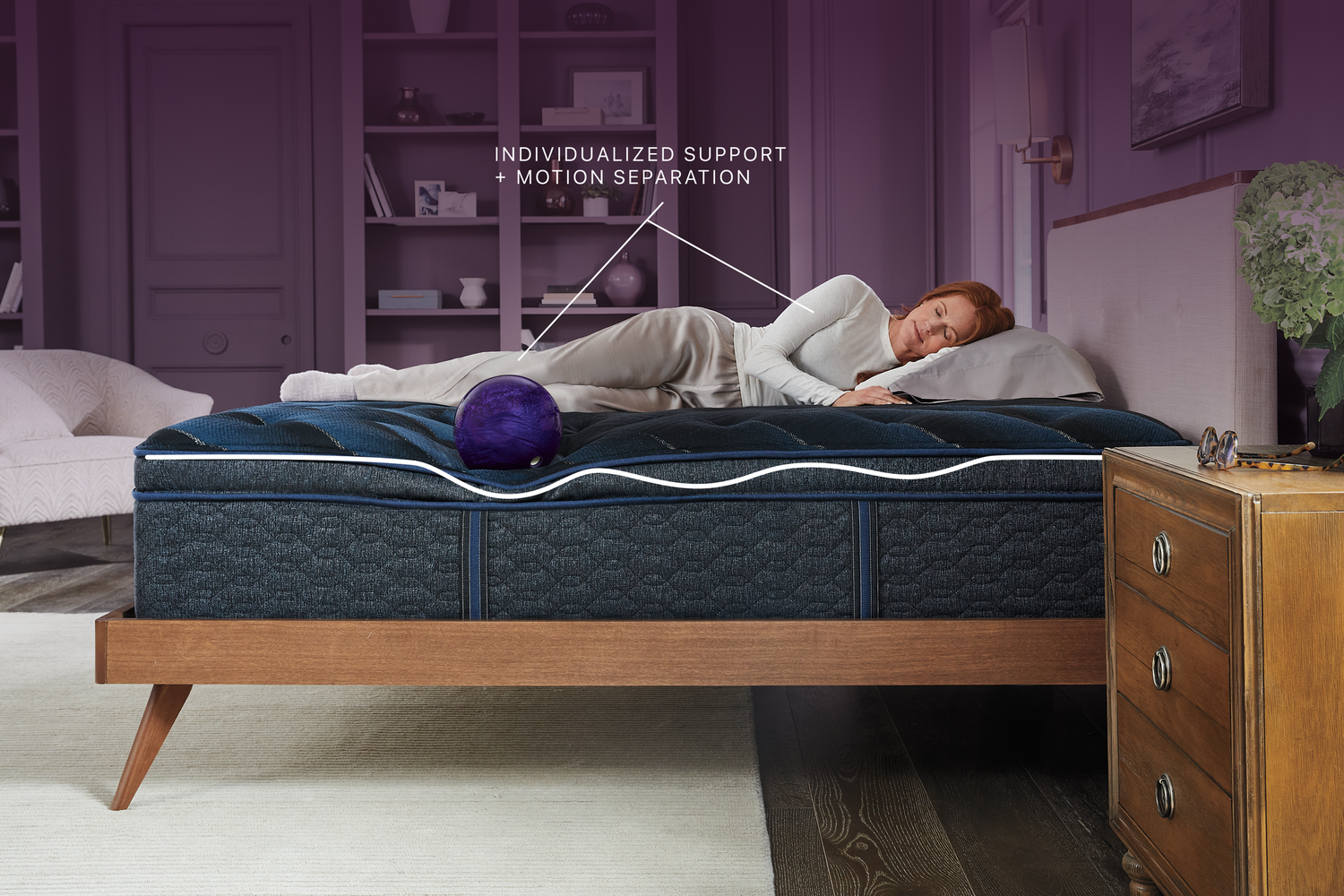 Person lying on a mattress with text about support and motion separation in a bedroom setting.