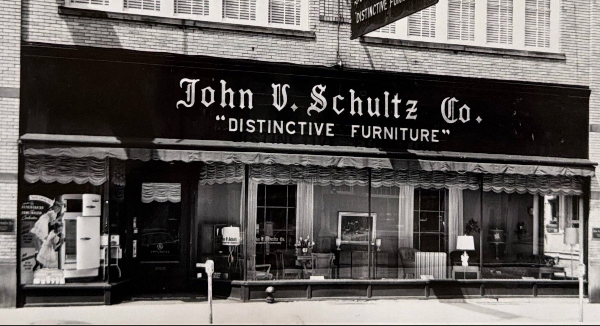 Black and white storefront photograph of John V. Schultz Co.