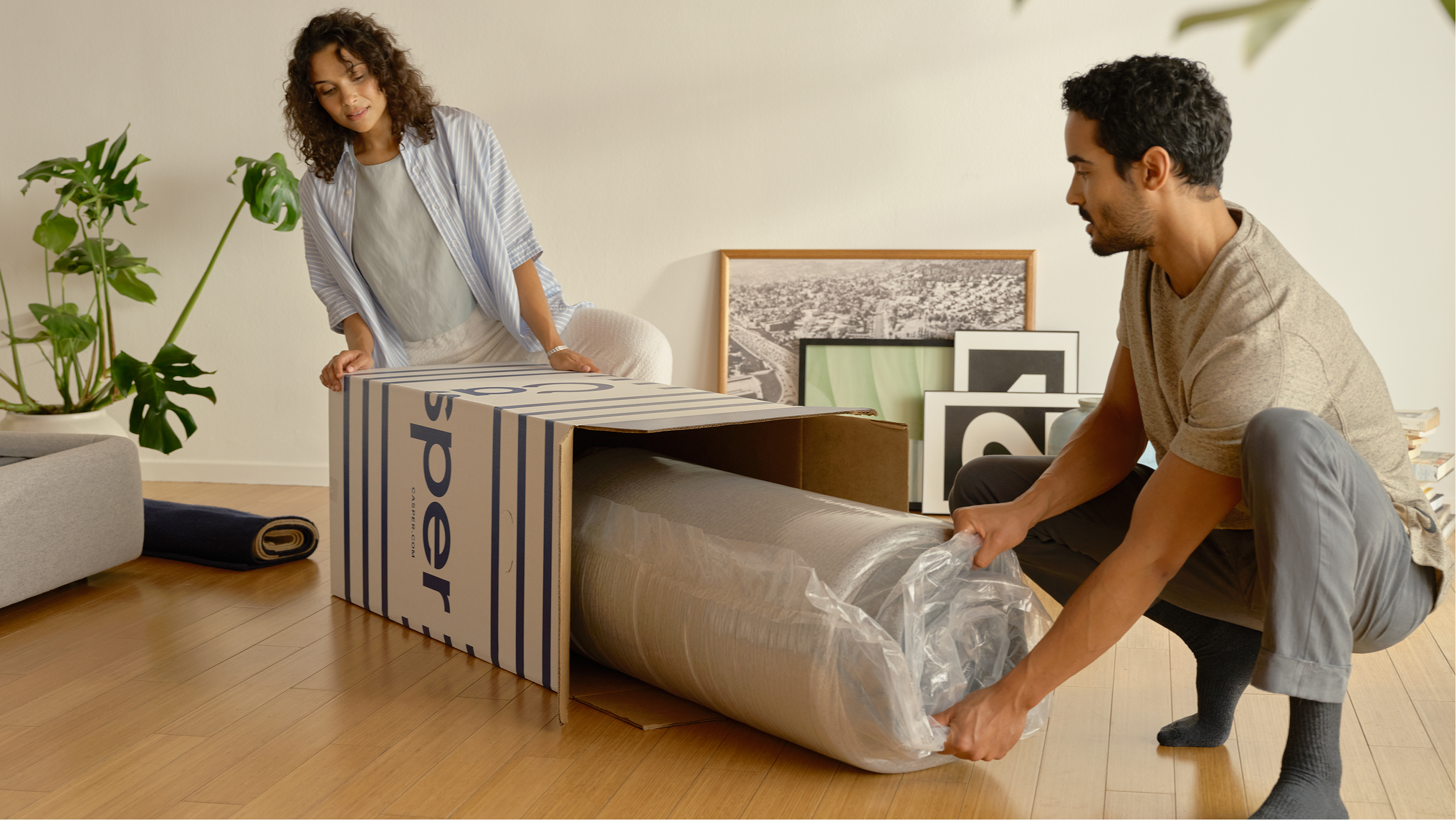 Two people unboxing a mattress in a box.